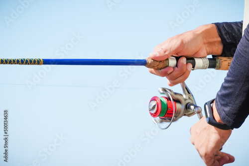 Tela man's hand holding a fishing rod