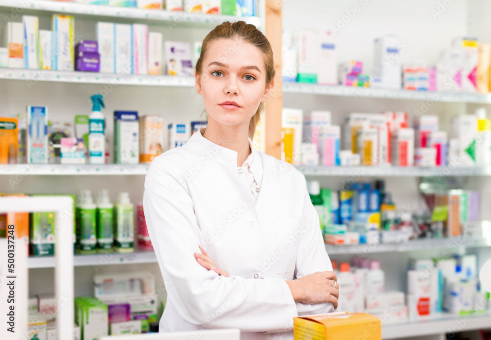 Portrait of young smiling cheerful positive female pharmacist in modern drugstore