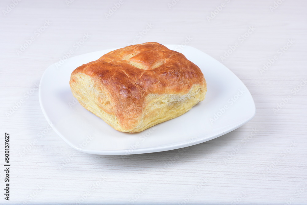 Ham and corn puff pastry, accompanied by sauce on a wooden background Ham and corn puff pastry, accompanied by sauce on a wooden background