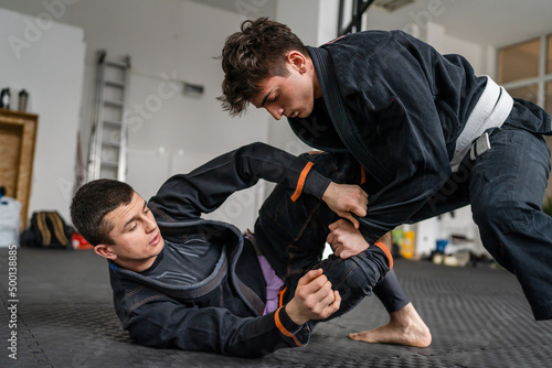 Fotografiet Two brazilian jiu jitsu BJJ athletes training at the academy martial arts ground