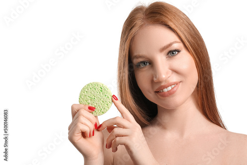 Beautiful woman with makeup sponge on white background photo