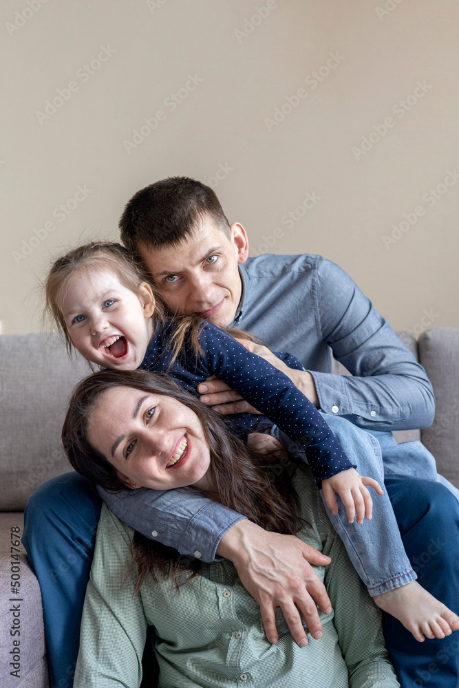 Lifestyle family. Mom dad and daughter are sitting on the couch and hugging. Lifestyle family. Mom dad and daughter are sitting on the couch and hugging.
