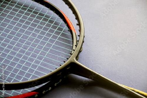 Badminton rackets on badminton indoor court floor, the upper racket is broken and has no string, soft and selective focus. © Sophon_Nawit