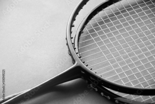 Badminton rackets on badminton indoor court floor, the upper racket is broken and has no string, soft and selective focus. © Sophon_Nawit