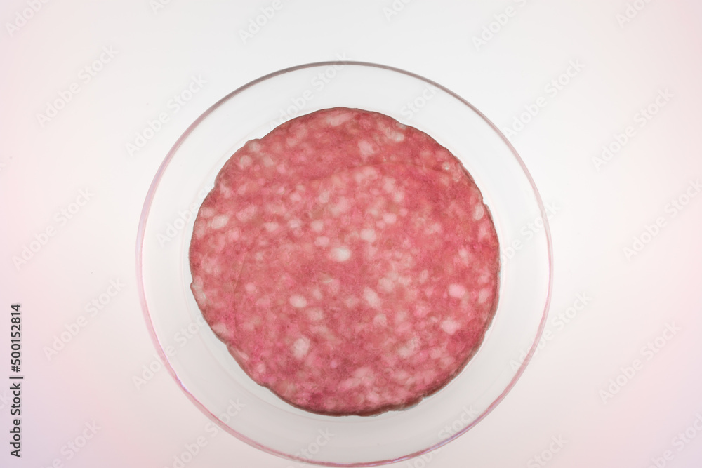 Thin salami slice directly above ,in a transparent dish Thin salami slice directly above ,in a transparent dish