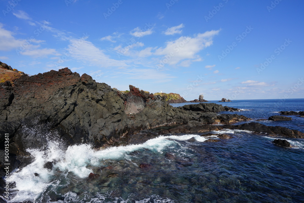 fascinating rock coast and distant lighthouse