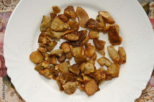 mushrooms fried with goldene apples sliced on a white plate in Bistrita,Romania