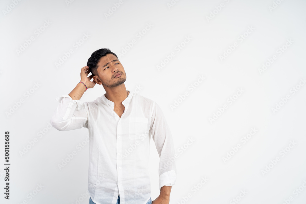 confused man with hands holding head while thinking looking up on isolated background confused man with hands holding head while thinking looking up on isolated background