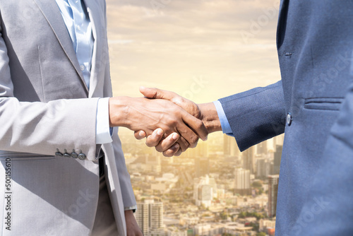 Businessmen shaking hands. Unknown businesspeople are shaking their hands after signing a contract, while standing together.