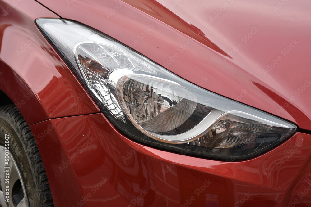 Car's exterior details.Red car .Front Light of a red Car