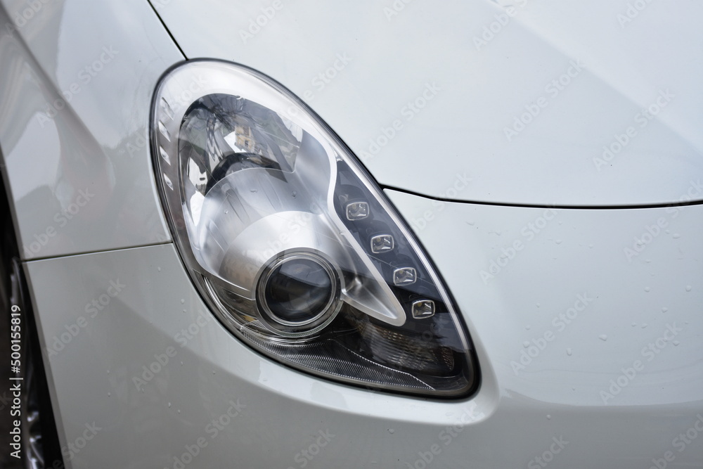 Car's exterior detail,new headlight on a  white silver car
