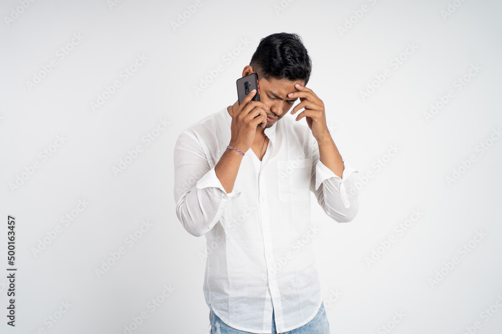 sad young man wearing white shirt making a call with copyspace on isolated background