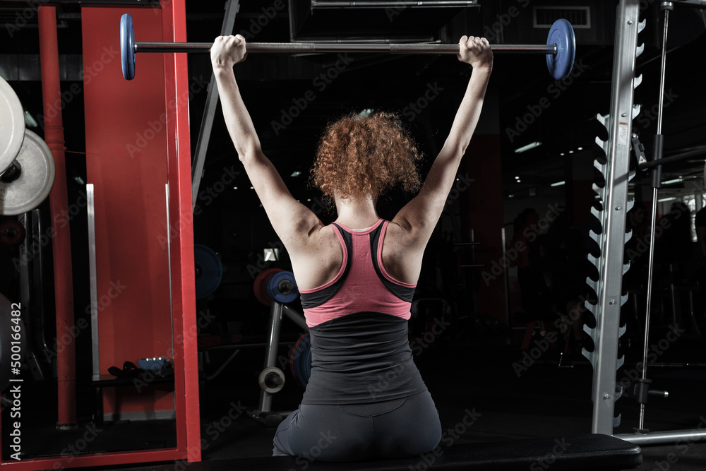 Woman bodybuilder engaged with a barbell in the gym Woman bodybuilder engaged with a barbell in the gym