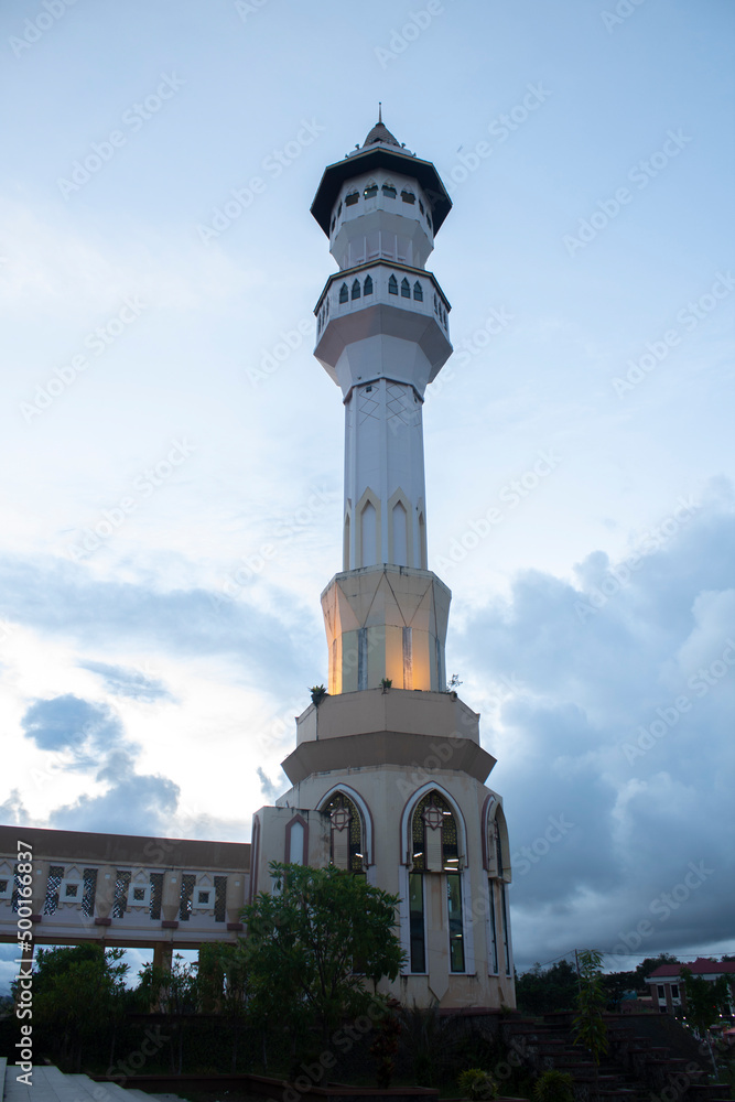 The minaret of the mosque and the light under it in the evening