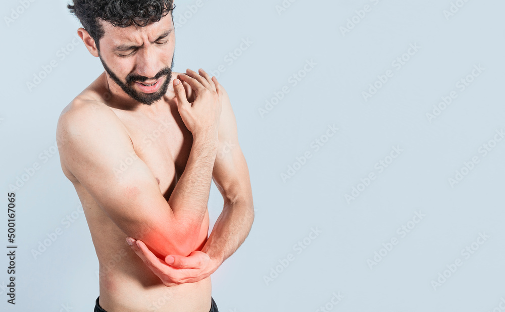 Fototapeta premium Person with elbow pain, concept of a man with elbow pain from rheumatism, shirtless man massaging sore elbow, man with elbow cramp