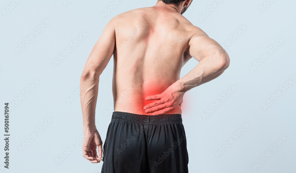 Fototapeta premium Man with back problems, shirtless man with back problems on isolated background, lumbar problems concept, rear view of sore man with back pain