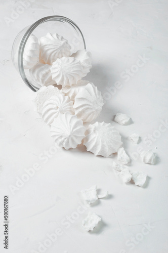 The French Meringue dessert was being sent out of a glass bowl, part of the meringue broke. Meringue is made from a mixture of beaten egg whites with sugar. Vertical snapshot.
