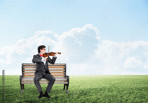 Young businessman plays the violin