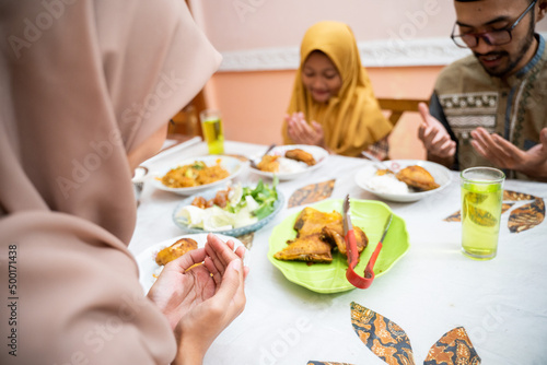muslim mother serving some food for family dinner during ramadan kareem