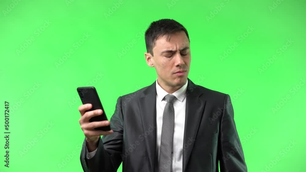 Serious man reading bad news in smartphone and feeling confused Serious man reading bad news in smartphone and feeling confused