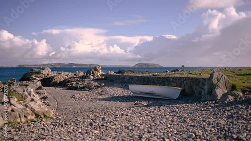 Timelapse of fluffy clouds over Bordeaux Harbour Guernsey on bright day Herm and Jethou in background and small boat on slipway photo