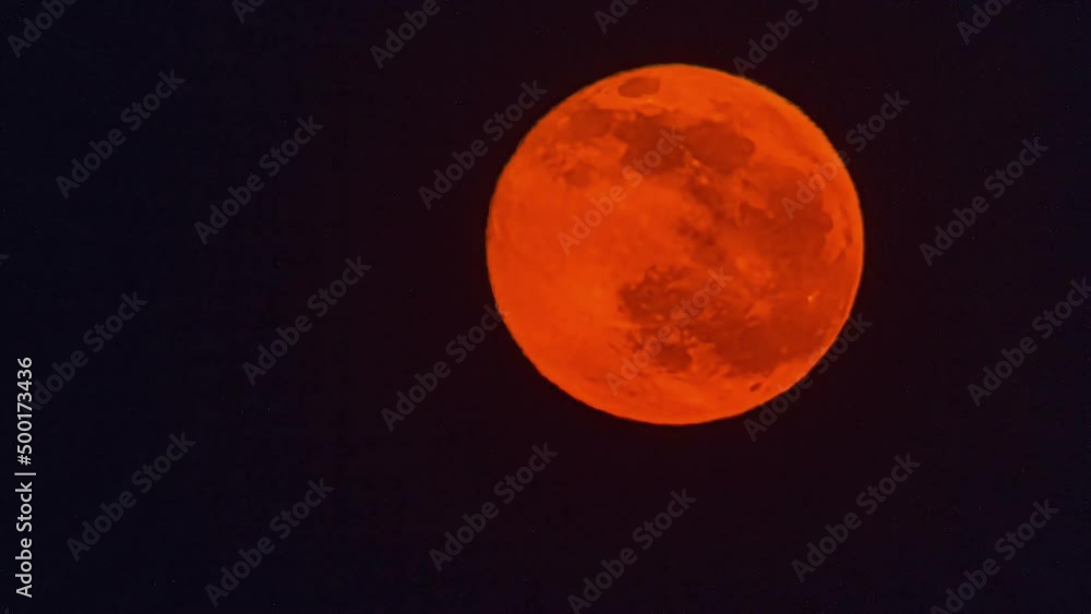 Close up view of Red full moon movement in timelapse in the night sky. Moon moving from top to bottom of view. Close up view of Red full moon movement in timelapse in the night sky. Moon moving from top to bottom of view.