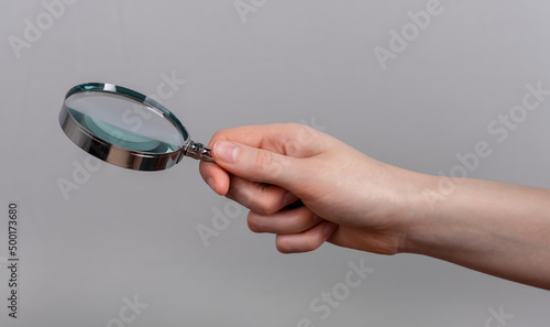 Woman hand holding magnifying glass. Data analysis, conducting research, careful information study concept. High quality photo