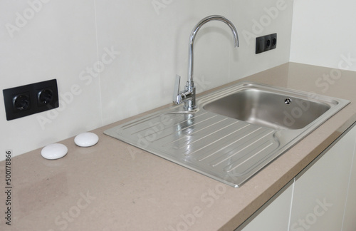 Kitchen metal sink with chome faucet. photo