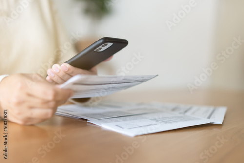 Woman paying bills using mobile phone. Cashless payment concept.