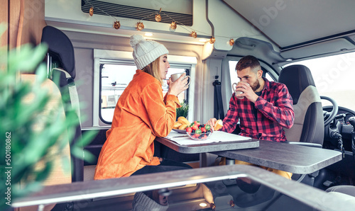 Friends having breakfast in a camper van in the morning photo