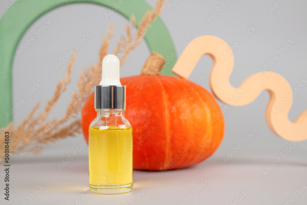 Mockup image of dropper bottle with natural organic cosmetic oil - pumpkin seed oil extract for skincare or hair with pumpkins as background. Beauty treatment, natural herbal cosmetics concept Mockup image of dropper bottle with natural organic cosmetic oil - pumpkin seed oil extract for skincare or hair with pumpkins as background. Beauty treatment, natural herbal cosmetics concept