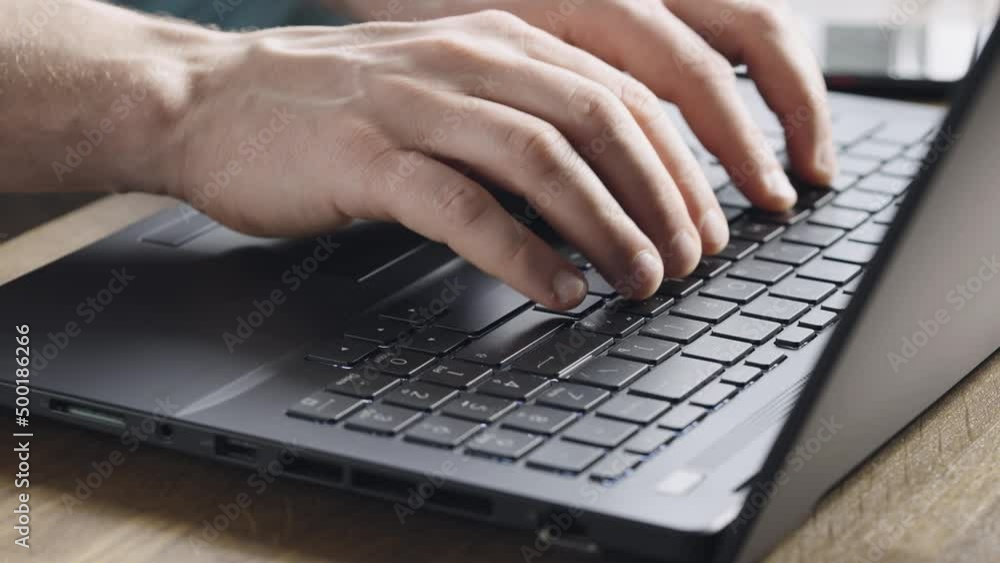 Close-up. Male hands are typing on a laptop keyboard. A man works on a computer. Close-up. Male hands are typing on a laptop keyboard. A man works on a computer.