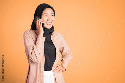 Young asian woman making a call using a cell phone on isolated background photo