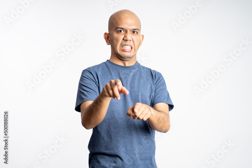 angry asian bald man pointing ahead while standing on isolated background photo