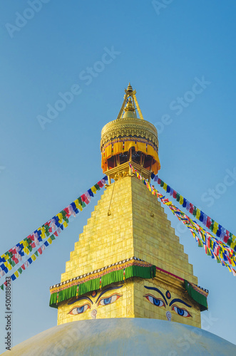 The golden spire of Bodhnath Stupa, Kathmandu, Nepal, with Buddhist prayer flags photo