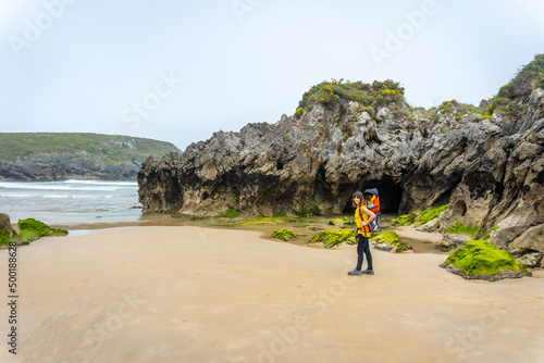A mother with her son at the Playa de Sorraos on the Borizu peninsula in the town of Llanes. Asturias. Spain