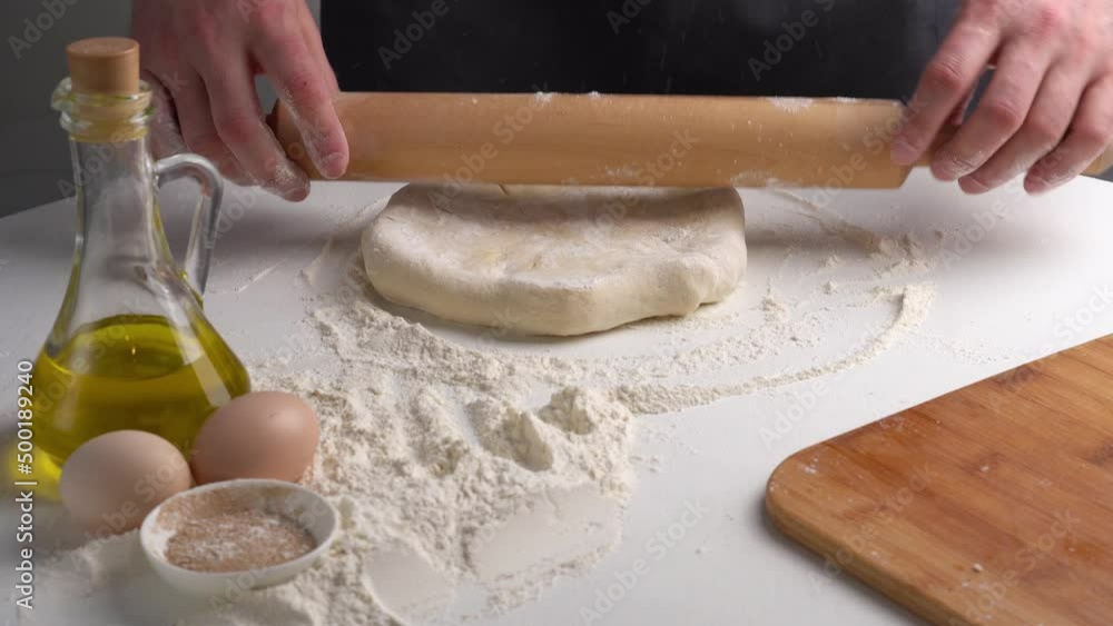 Chef makes Ossetian pie and rolls out dough with rolling pin. Caucasian traditional food Chef makes Ossetian pie and rolls out dough with rolling pin. Caucasian traditional food