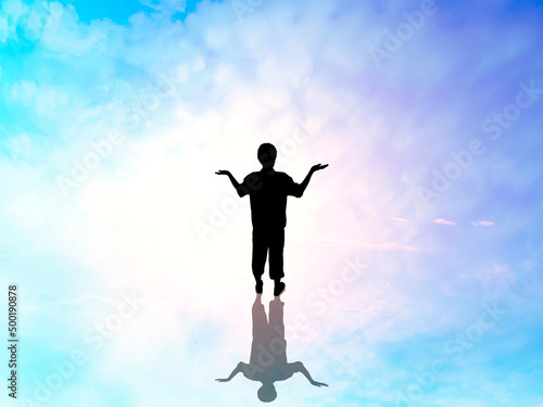 両手を上に向けて立つ男性全身シルエット_スピリチュアルな空背景