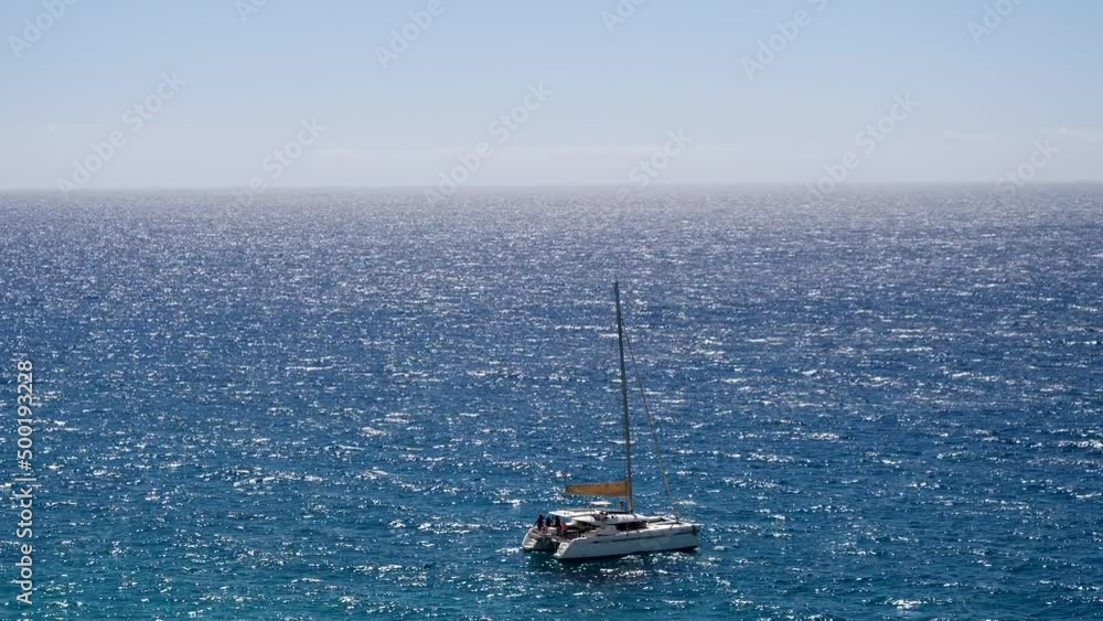 Wide shot showing parking sailing boat on beautiful Blue Atlantic during sunny day Wide shot showing parking sailing boat on beautiful Blue Atlantic during sunny day