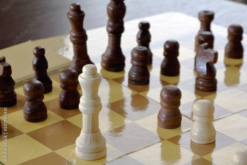 Chess pieces standing on the chessboard on the table Chess pieces standing on the chessboard on the table
