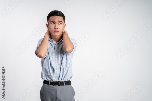 asian young businessman holding his head feeling unsure over isolated background © Odua Images