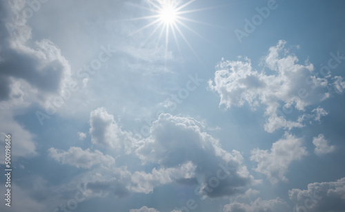 Beautiful blue sky bright midday sun with fluffy clouds. Summer sunshine with white cloudscape background. Natural scenic sunny day horizon sky wallpaper backdrop. 