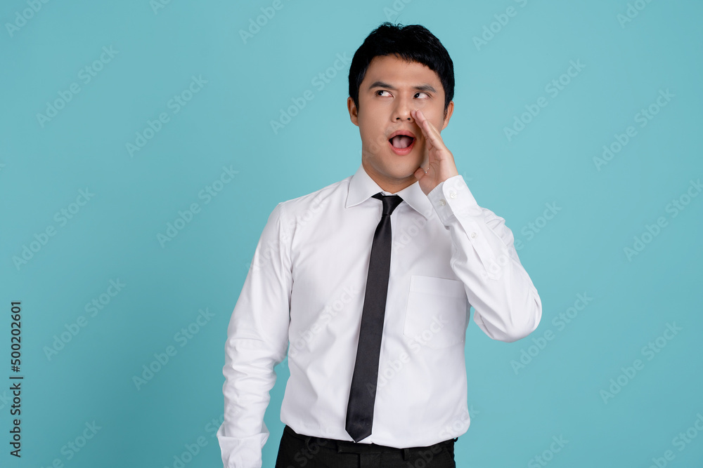 Close-up portrait of Asian male college student saying rumour copy space isolated on light blue color background Close-up portrait of Asian male college student saying rumour copy space isolated on light blue color background