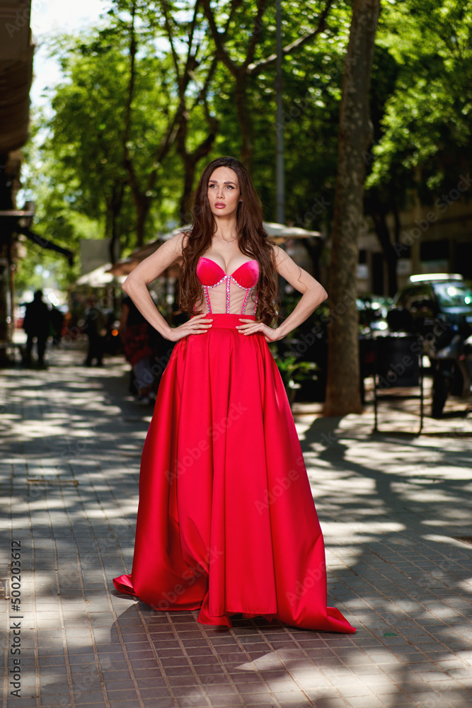 Attractive beautiful girl in a red dress standing on the city Attractive beautiful girl in a red dress standing on the city