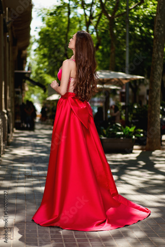 Attractive beautiful girl in red dress in the city
