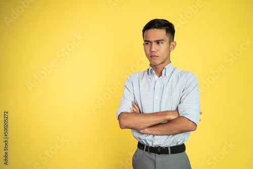 asian young businessman with serious expression crossed his arm and standing over isolated background