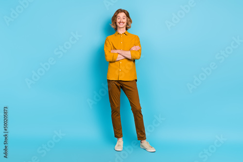 Full length body size view of attractive cheerful glad content guy folded arms isolated over bright blue color background