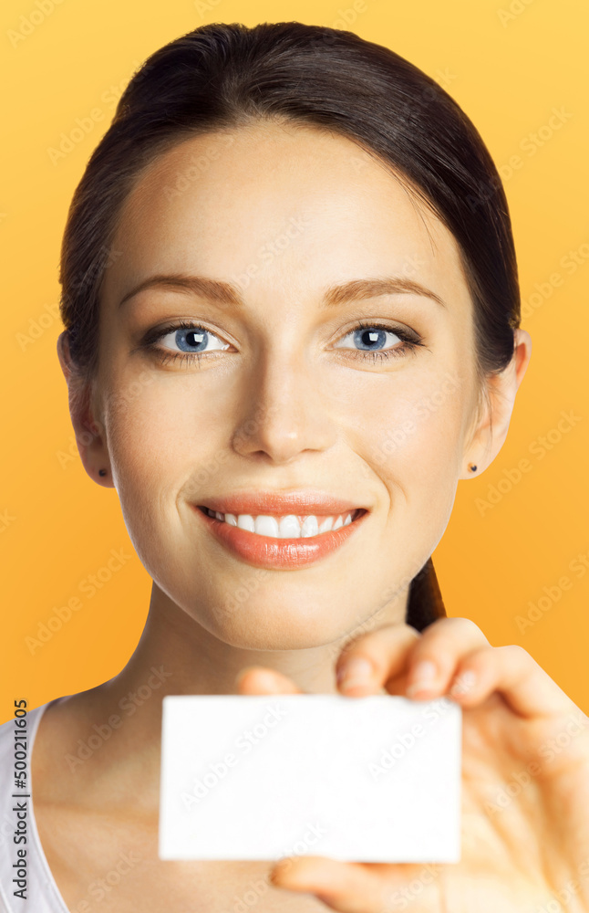 Closeup portrait of smiling businesswoman showing mockup empty businesscard or plastic credit card, with copy space, over orange yellow color background. Brunette business woman at studio image. Closeup portrait of smiling businesswoman showing mockup empty businesscard or plastic credit card, with copy space, over orange yellow color background. Brunette business woman at studio image.
