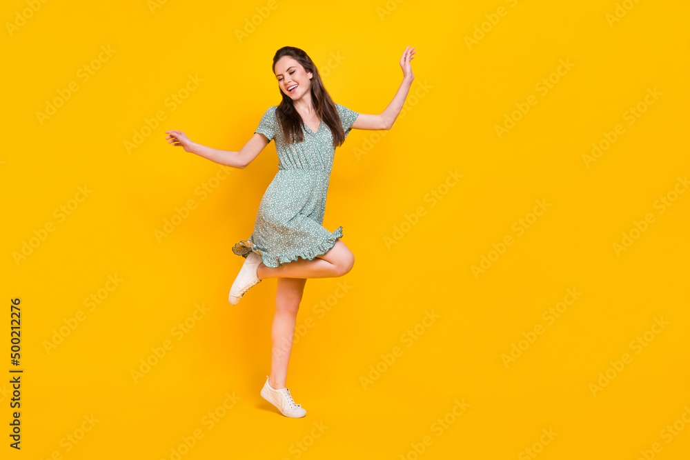 Photo of cute excited lady dressed green dress dancing empty space isolated yellow color background Photo of cute excited lady dressed green dress dancing empty space isolated yellow color background