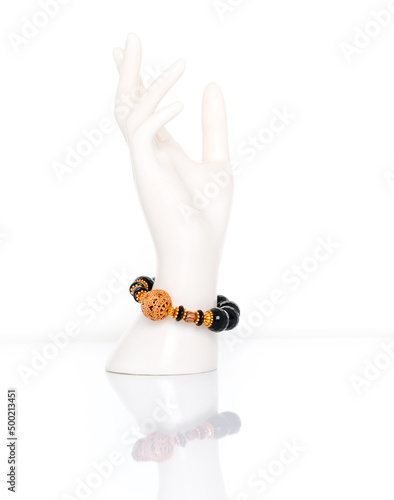 Black Spinel bracelet with antique gold beads on plastic mannequin female hand. Collection of natural gemstones accessories. Studio shot